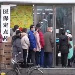 citizens of wuhan lining up outside of a drug store to buy masks during the wuhan coronavirus outbreak