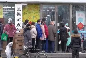 citizens of wuhan lining up outside of a drug store to buy masks during the wuhan coronavirus outbreak