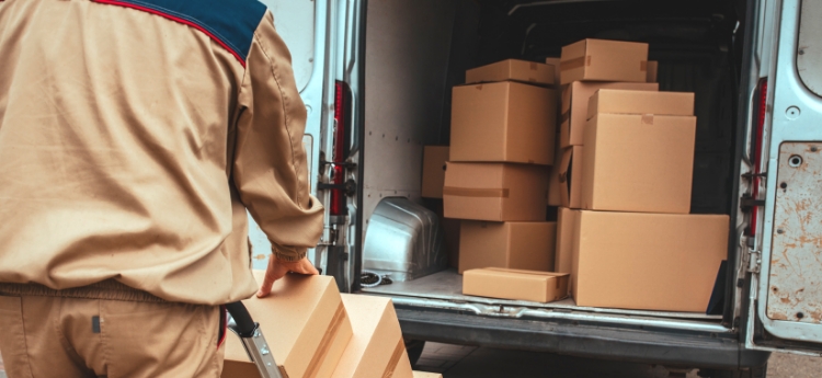 A photo of a person loading packages in the back of a truck