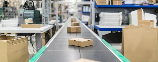A photo of packages moving along a conveyor belt in a fulfilment center