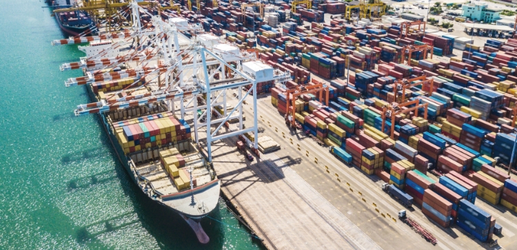 Ship at dock of port full of shipping containers.