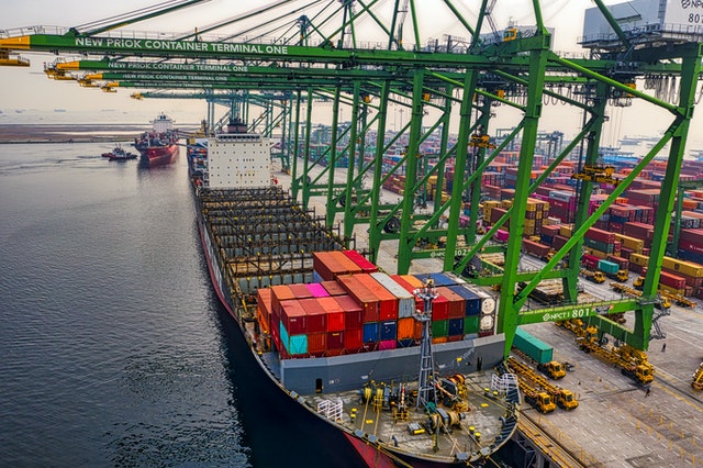 Image of a blue and red cargo ship on dock.